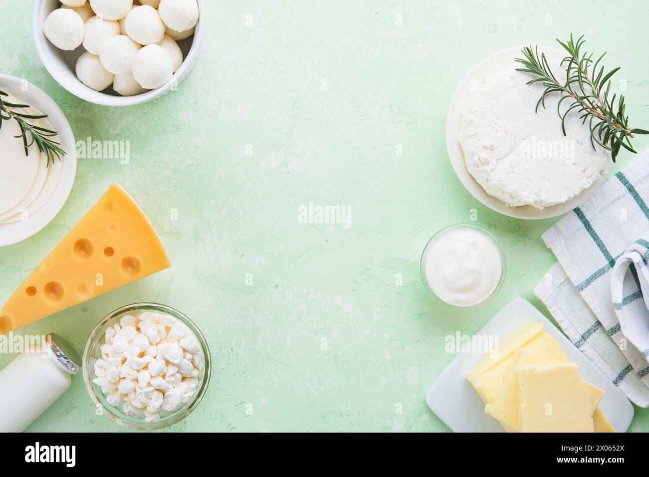 Milcherzeugnisse oder landwirtschaftliche Erzeugnisse. Frische Bio-Milchprodukte Milch, Hüttenkäse, Butter, Sahne, Joghurt, Sauerrahm und Mozzarella auf einem hellgrünen Stockfoto