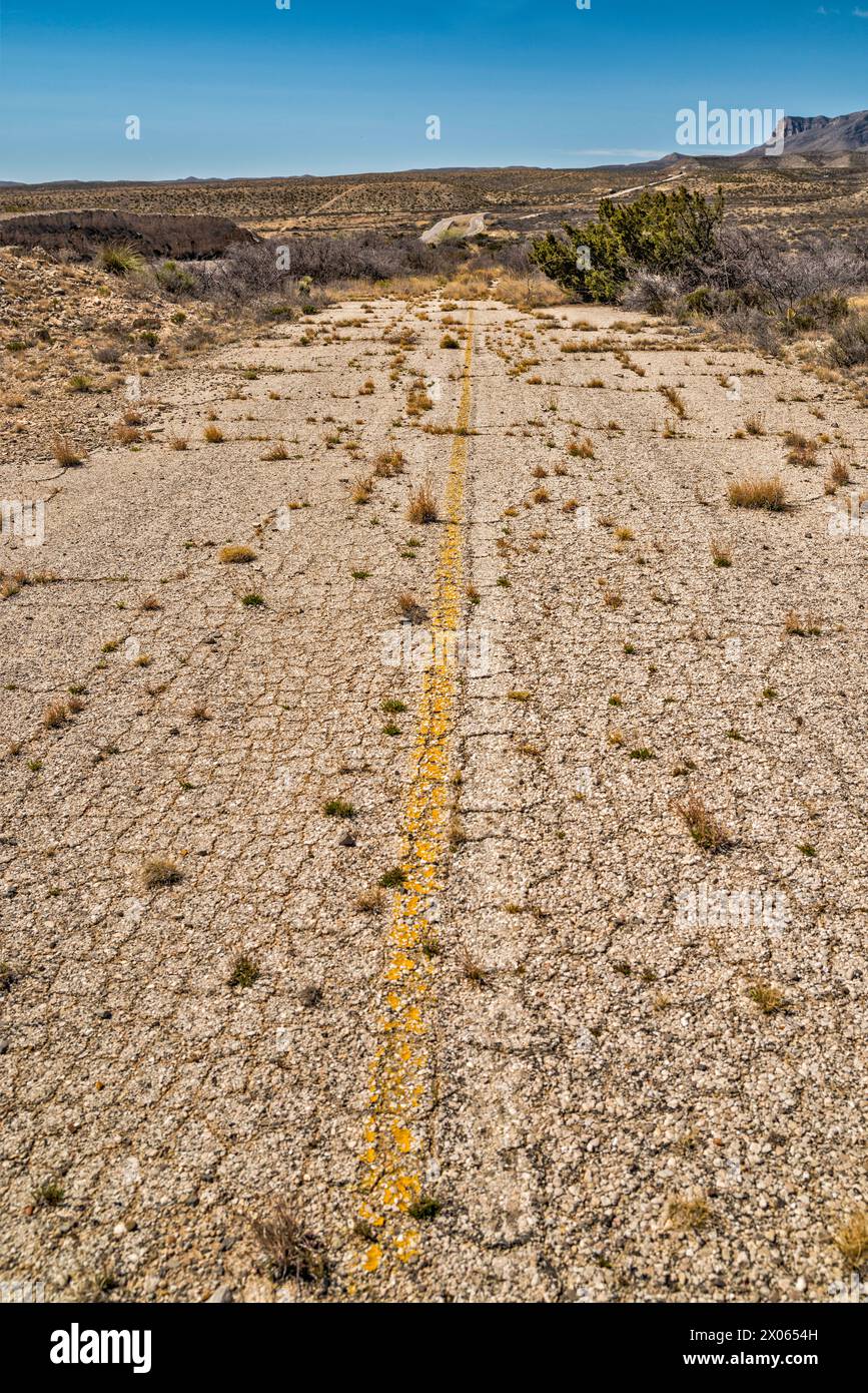 Verlassener Abschnitt der US-180, US-62 Highway mit Überwuchs, Guadalupe Mountains in der Ferne, Texas, USA Stockfoto