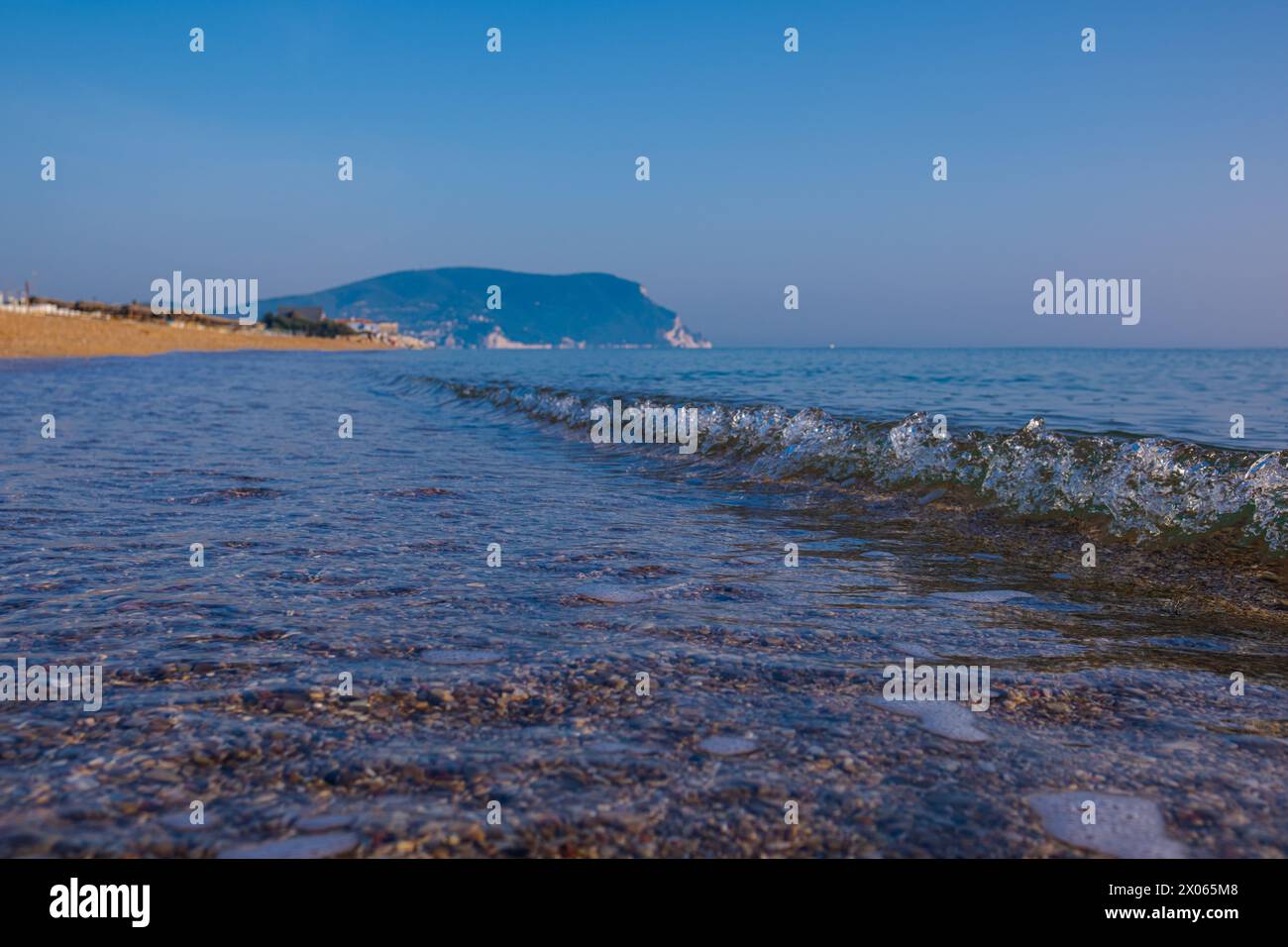Wunderschönes ruhiges Meer an einem sonnigen Tag. Meereslicht-Surf-Aufnahme aus nächster Nähe. Eine kleine Welle und ein Meeresschaum glitzern in der Sonne. Stockfoto