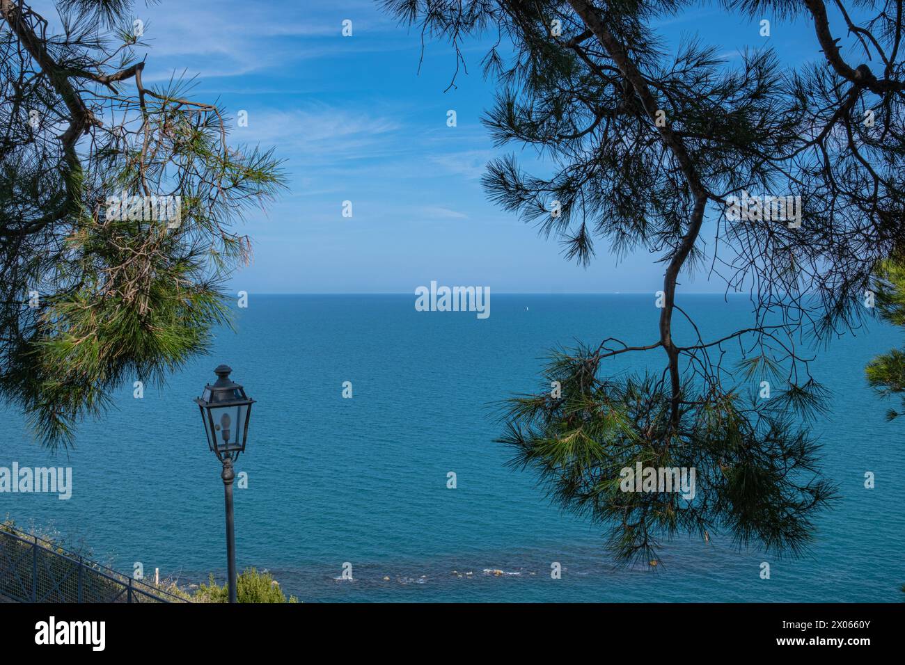 Strand der zwei Schwestern in Italien, Numana. Wunderschöner Blick auf den beliebten Strand. Kiefern und andere Vegetation am Ufer und blaues Wasser und darüber Stockfoto