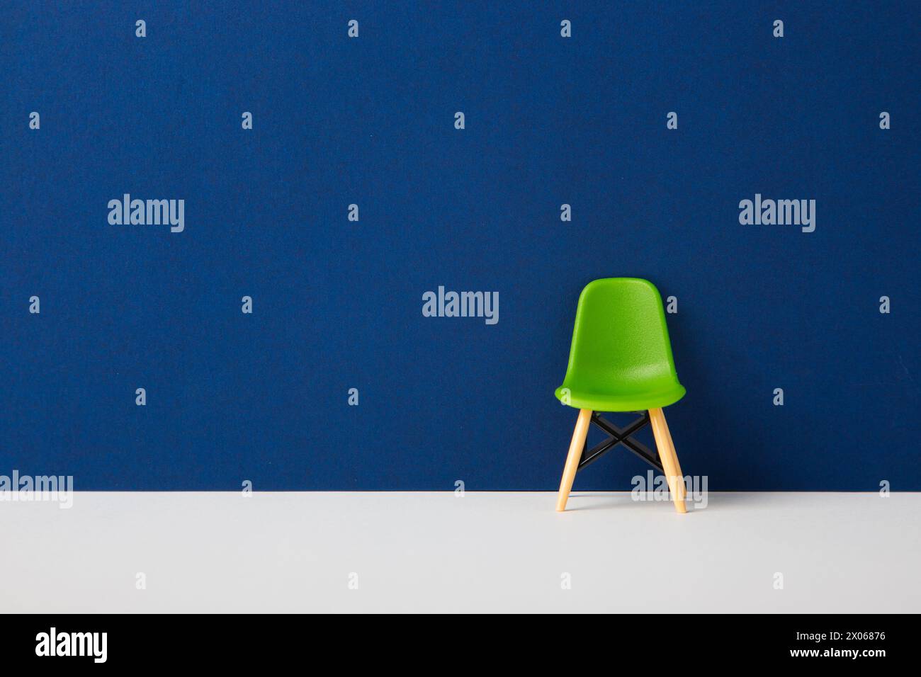 Grüner Stuhl an einer blauen Wand. Stockfoto