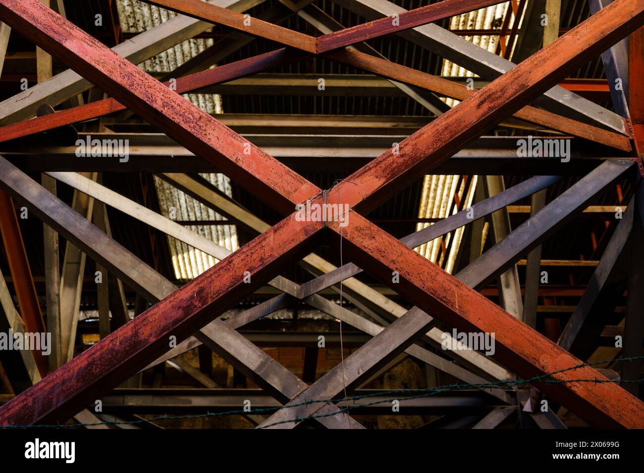 Rote Stahlträger, die X in Metallstruktur bilden Stockfoto