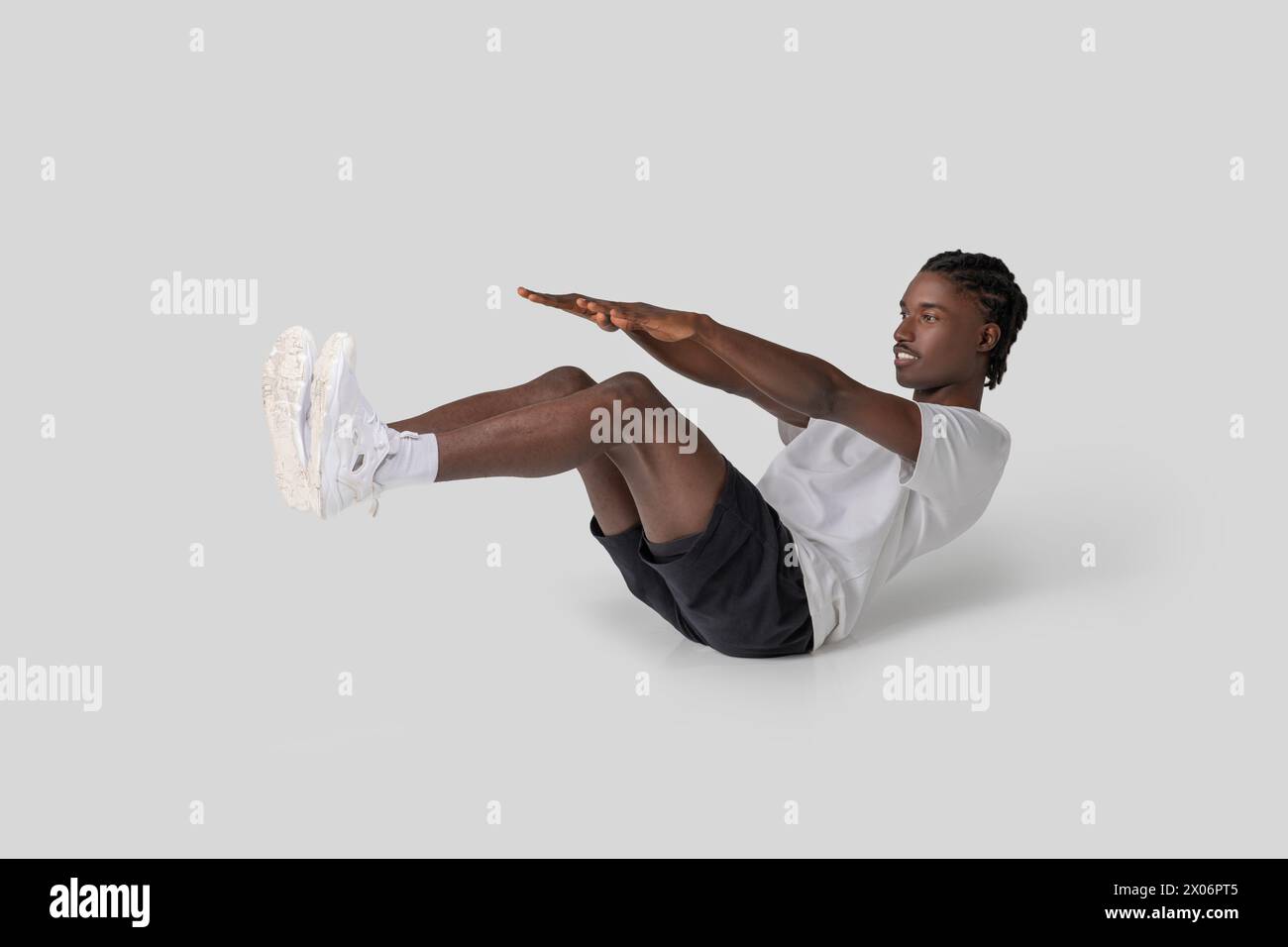 Mann, der eine V-Sit-Bauchübung auf weißem Hintergrund durchführt Stockfoto