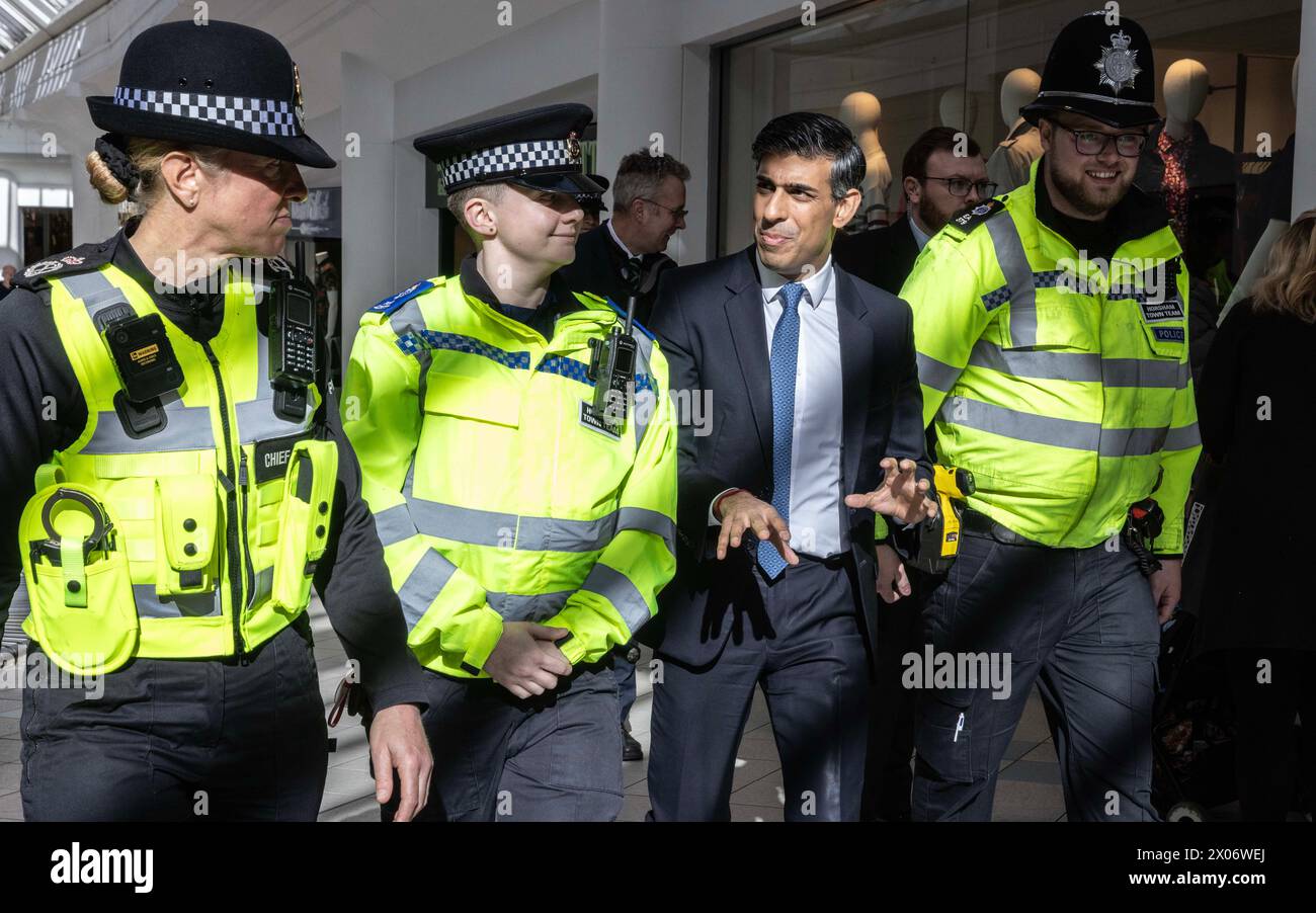 Premierminister Rishi Sunak spaziert durch das Swan Walk Einkaufszentrum in Horsham, zusammen mit Polizisten während seines Besuchs in West Sussex. Bilddatum: Mittwoch, 10. April 2024. Stockfoto