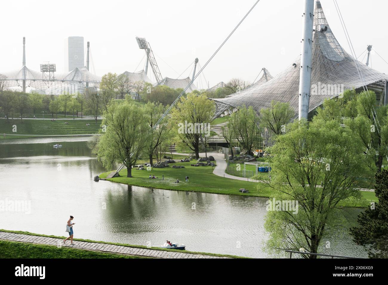 Olympiapark München, Olympiasee mit rechts der Schwimmhalle und dem Olympiastadion im Hintergrund Stockfoto