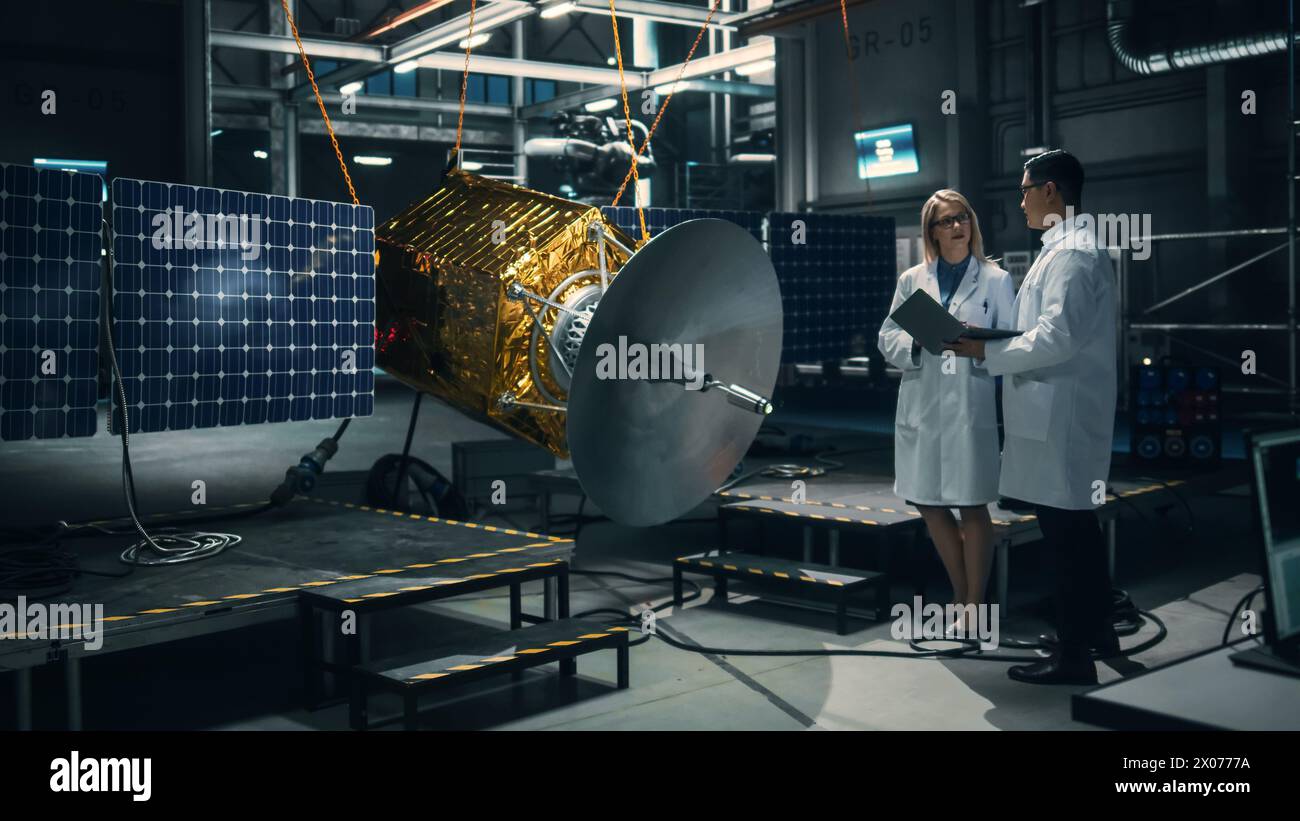 Ingenieur und Techniker, die an der Satellitenkonstruktion arbeiten. Luft- und Raumfahrtbehörde: Ein Team von Wissenschaftlern, das technologische Ausrüstung und Tablet-Computer zur Entwicklung von Raumfahrzeugen für die Weltraumforschung nutzt. Stockfoto