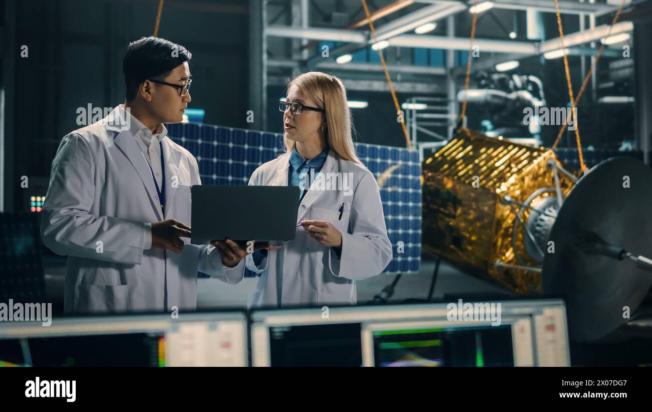 Ingenieur und Techniker, die an der Satellitenkonstruktion arbeiten. Luft- und Raumfahrtbehörde: Ein Team von Wissenschaftlern, die technologische Ausrüstung und Laptop-Computer nutzen, um Raumfahrzeuge für die Weltraumforschung zu entwickeln. Stockfoto