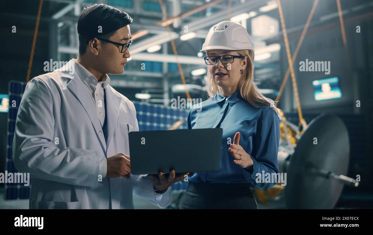 Ingenieur und Techniker, die an der Satellitenkonstruktion arbeiten. Luft- und Raumfahrtbehörde: Ein Team von Wissenschaftlern, die technologische Ausrüstung und Laptop-Computer nutzen, um Raumfahrzeuge für die Weltraumforschung zu entwickeln. Stockfoto