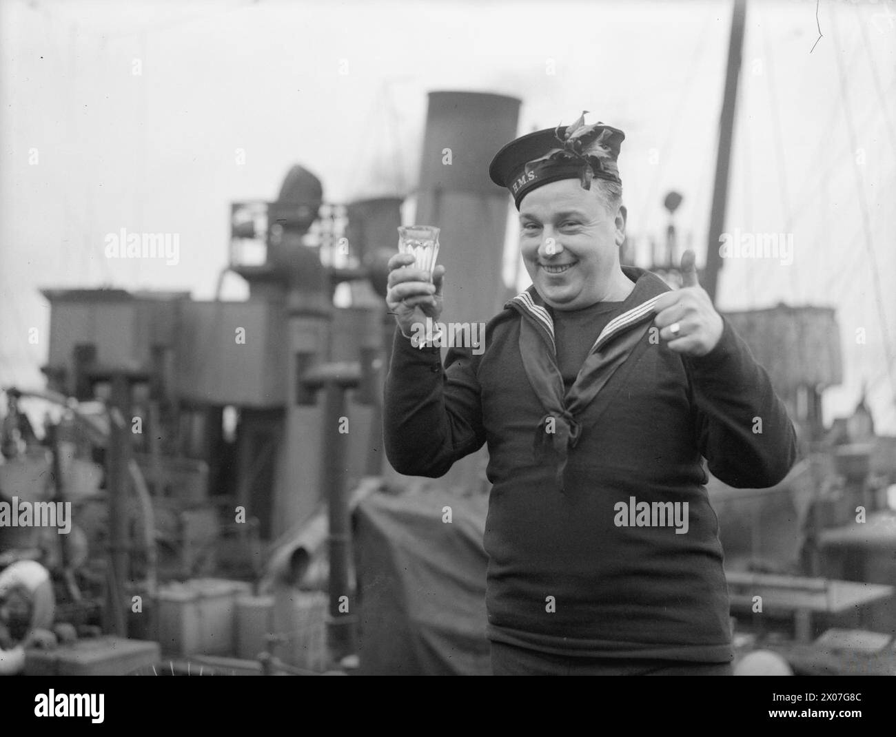 Stoker G A Revell of the Royal Fleet Reserve trinkt im Dezember 1942 seinen Weihnachtsrum auf der Marinebasis Harwich. Stockfoto