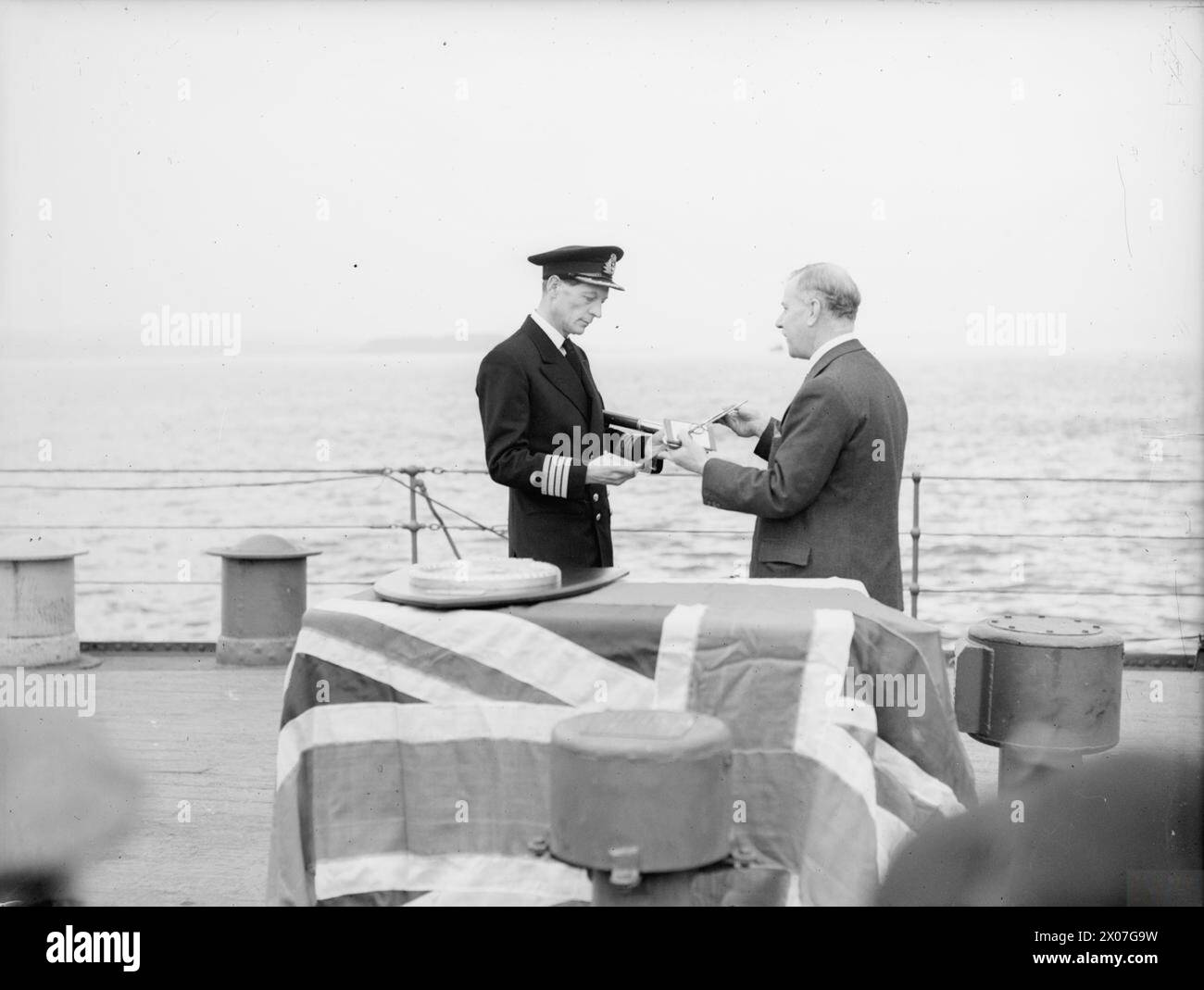 Am 15. Oktober 1942 wurde in Greenock der Kreuzer der Dido-Klasse HMS Bellona von Fifeshire offiziell angenommen. Lord Elgin übergab die Gedenktafel Captain C F Norris, RN. Stockfoto