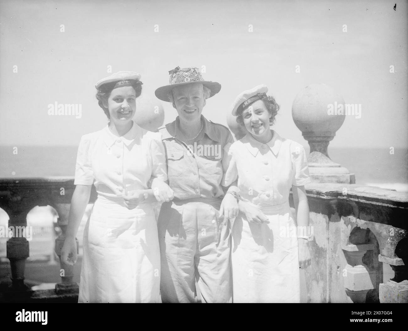 Am 20. Oktober 1945 besuchten Gracie Fields Einheiten der British East Indies Fleet in Trincomalee, Ceylon. Sie trägt ihren Buschhut mit Abzeichen und posiert mit Wren Beryl Flynn und Wren Eileen Garritt in Colombo. Stockfoto Am 20. Oktober 1945 besuchten Gracie Fields Einheiten der British East Indies Fleet in Trincomalee, Ceylon. Sie trägt ihren Buschhut mit Abzeichen und posiert mit Wren Beryl Flynn und Wren Eileen Garritt in Colombo. Stockfoto
