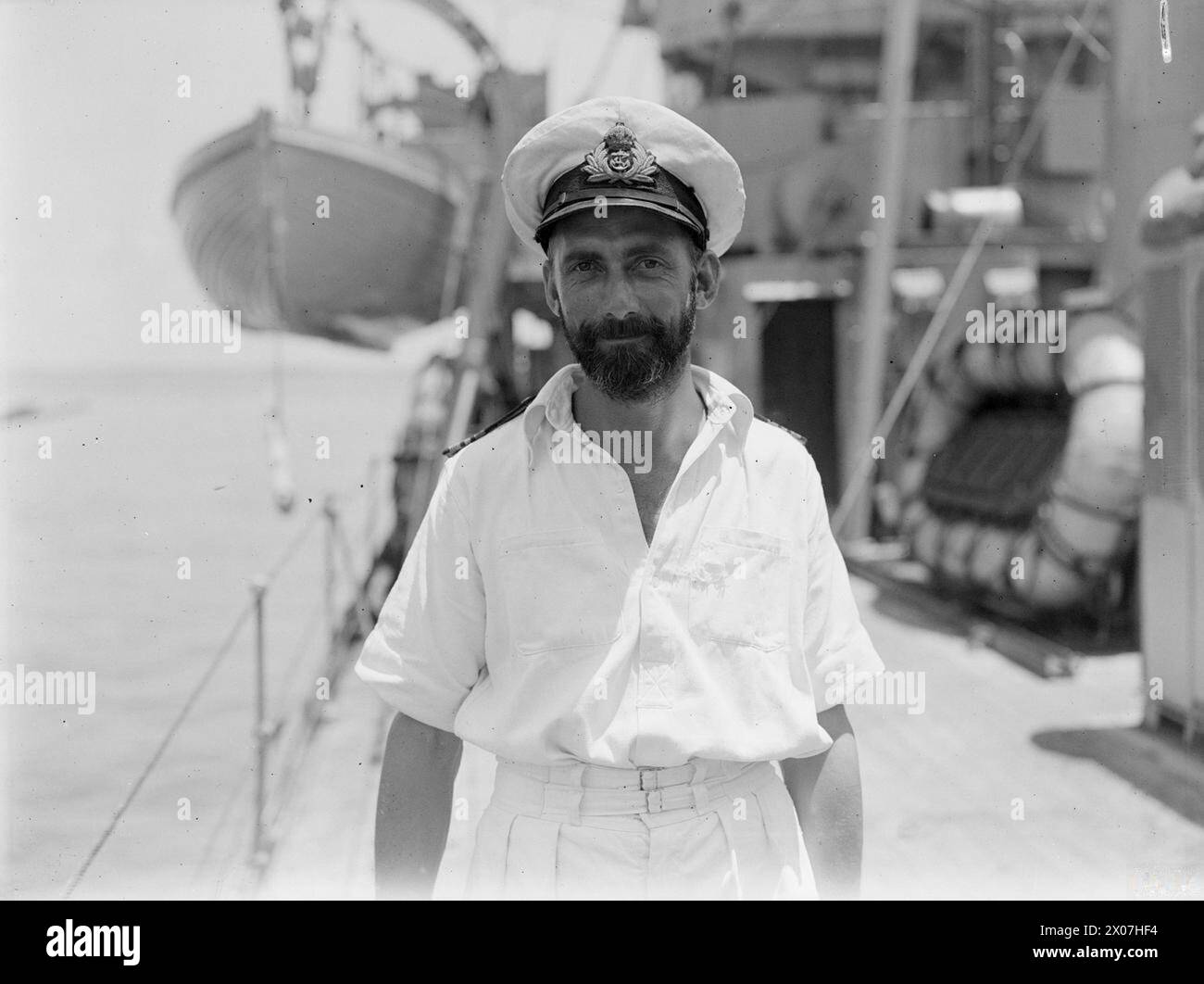 Am 22. März 1945 stellt die britische Armee der HMS Flamingo eine japanische Flagge als Anerkennung für die Artillerieunterstützung der britischen Truppen vor. Lieutenant Commander T. H. B. Pounds, RN, ist Kommandant. Fotografische Aufzeichnungen dokumentieren militärische Zeremonie und Marinekooperation. Stockfoto