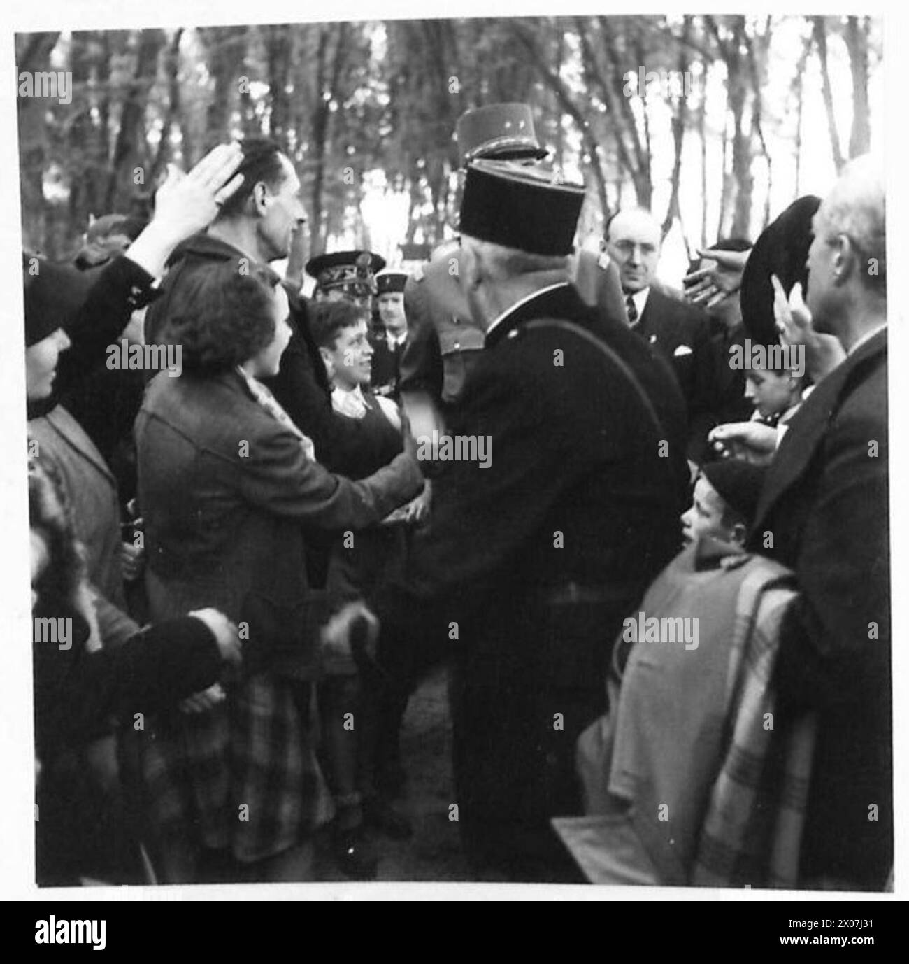 General Charles de Gaulle wird während des Zweiten Weltkriegs von einer Menge von Bewunderern in Bayeux, Frankreich, umgeben, mit britischen Armeepersonal der 21. Armeegruppe in der Gegend gezeigt. Stockfoto