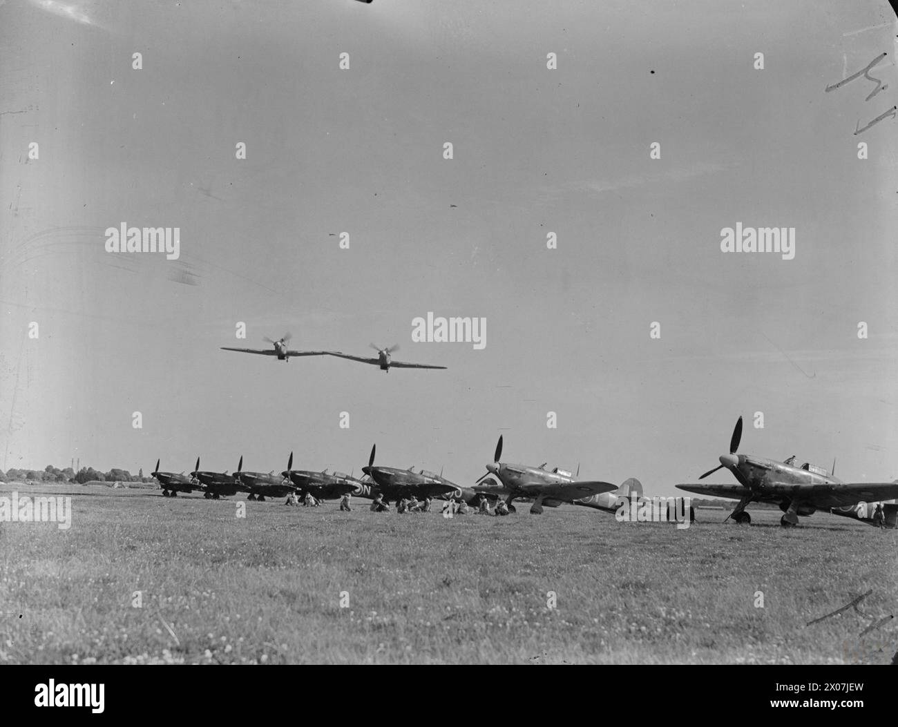 KÖNIGLICHE LUFTWAFFE, 1939-1945. - Zwei Hawker Hurrikan Mark IIS von No 43 Squadron RAF überqueren andere Flugzeuge der Squadron, die in Tangmere, Sussex Royal Air Force, Royal Air Force Regiment, Sqdn, 43 aufgestellt sind Stockfoto