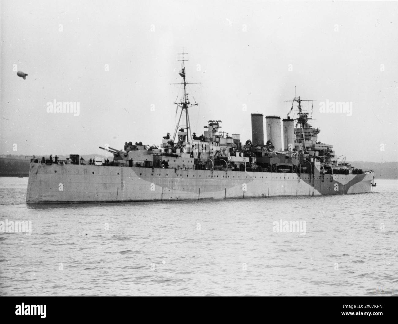 Die HMS Devonshire wird beim Fallenlassen oder Wiegen des Ankers während der Marineoperationen gezeigt. Stockfoto