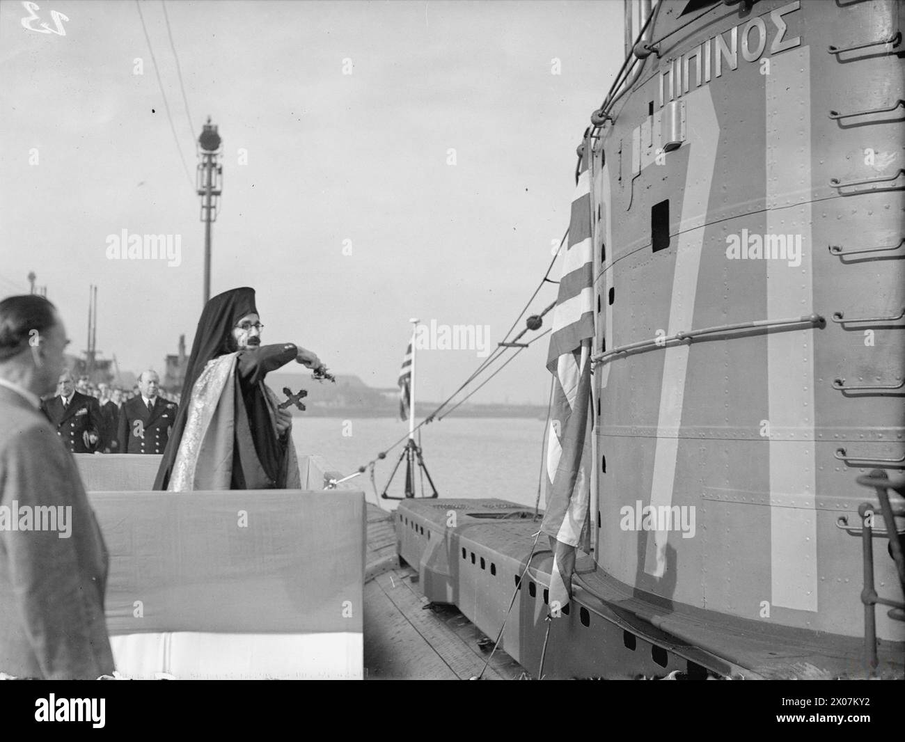 Am 28. Oktober 1943 übergaben britische Schiffbauer in Barrow-in-Furness das U-Boot Pipinos an die Royal Hellenic Navy, wo Beamte und ein griechischer Priester anwesend waren. Stockfoto Am 28. Oktober 1943 übergaben britische Schiffbauer in Barrow-in-Furness das U-Boot Pipinos an die Royal Hellenic Navy, wo Beamte und ein griechischer Priester anwesend waren. Stockfoto