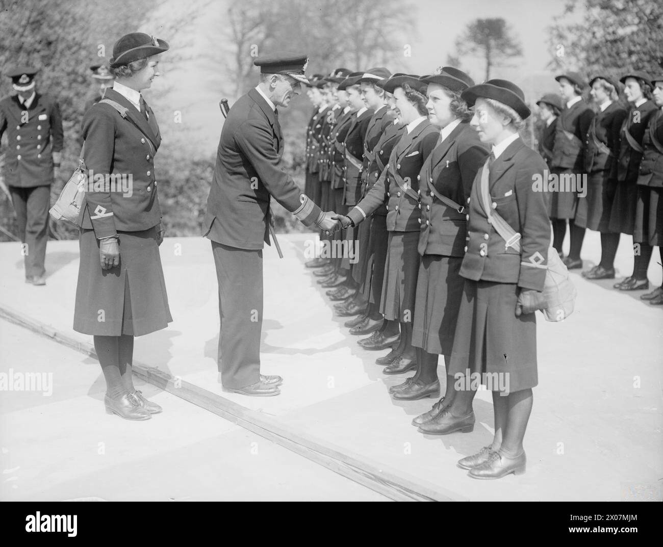 Konteradmiral C.S. Holland, Direktor der Admiralty Signalling Department, inspiziert WRENS am 8. Mai 1942 an einer Marinesignal-Station in Greenock und schüttelt dabei Offiziere. Stockfoto