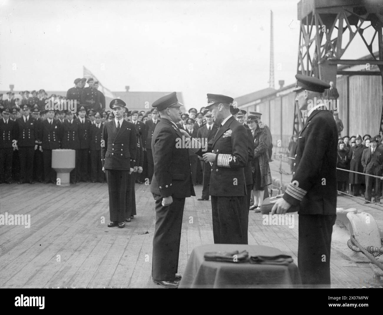 König George VI. Überreicht die DSM an Chief Petty Officer William James Johnson an Bord der HMS Duke of York während einer Einschiffung auf dem Quarterdeck, bevor das Schiff Liverpool in östliche Gewässer verließ. Stockfoto