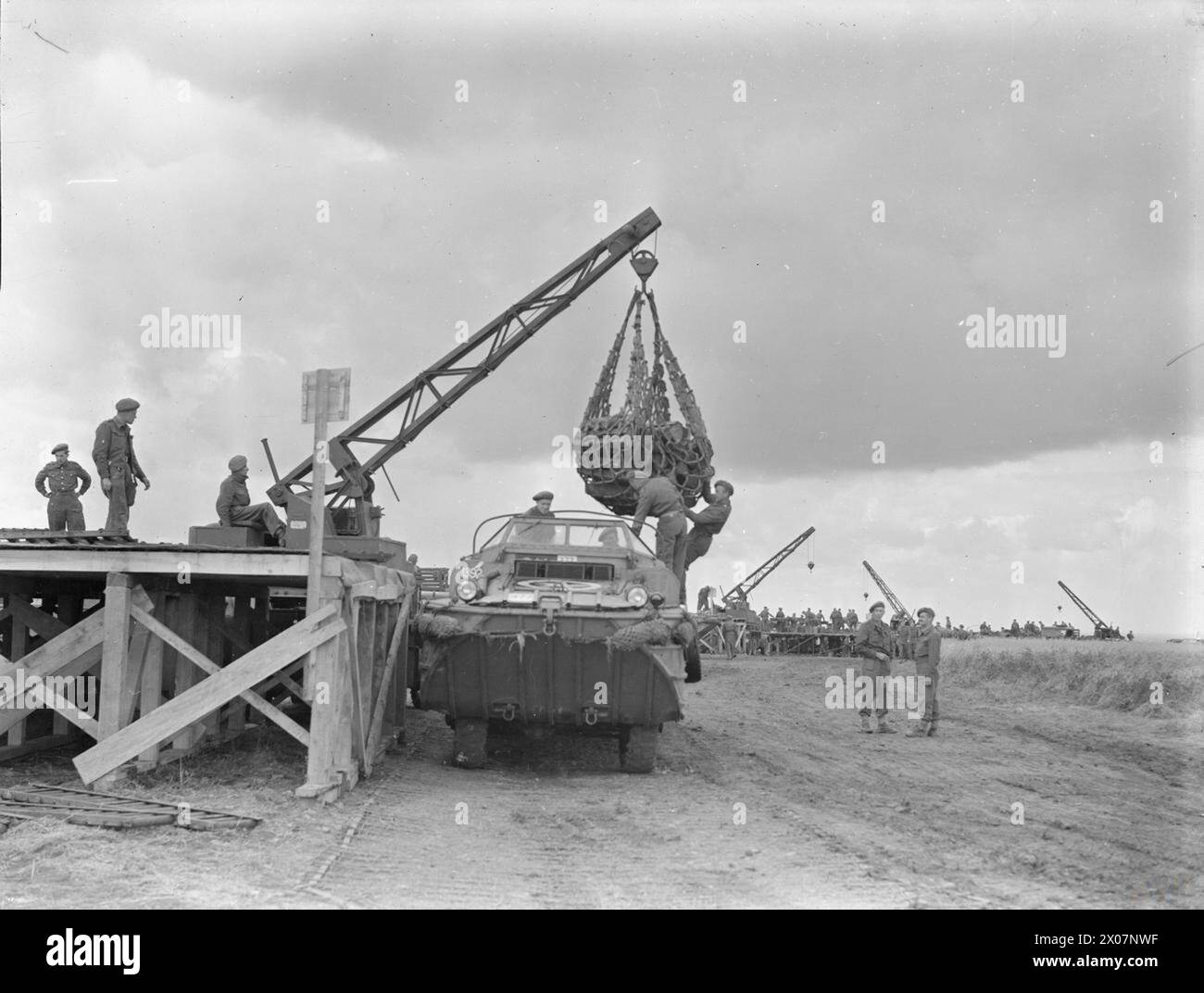Vom 25. Bis 28. Juni 1944 wurde der künstliche Hafen Mulberry B in Arromanches in Betrieb genommen, mit Port en Bessin für Erdöl und einem Entenlandefahrzeug, das mit einem Kran entladen wurde. Stockfoto
