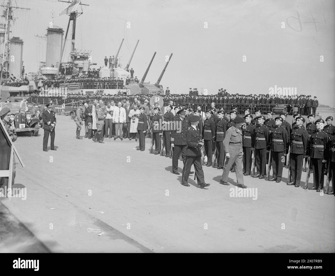 Feldmarschall Montgomery besuchte am 12. Mai 1945 Schiffe der britischen Flotte in Kopenhagen, begleitet von Vizeadmiral R. V. Holt. Er inspizierte die Royal Marine Guard of Honour, während der Kreuzer HMS Dido mit erhöhten Geschützen und Besatzung an Deck sichtbar ist. Stockfoto