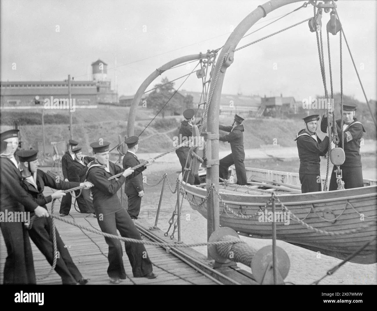 Südamerikanische Auszubildende bereiten sich darauf vor, einen Walfänger zu senken und üben die Handhabung eines Bootes unter Segel als Teil der Ausbildung zur British Navy. Stockfoto