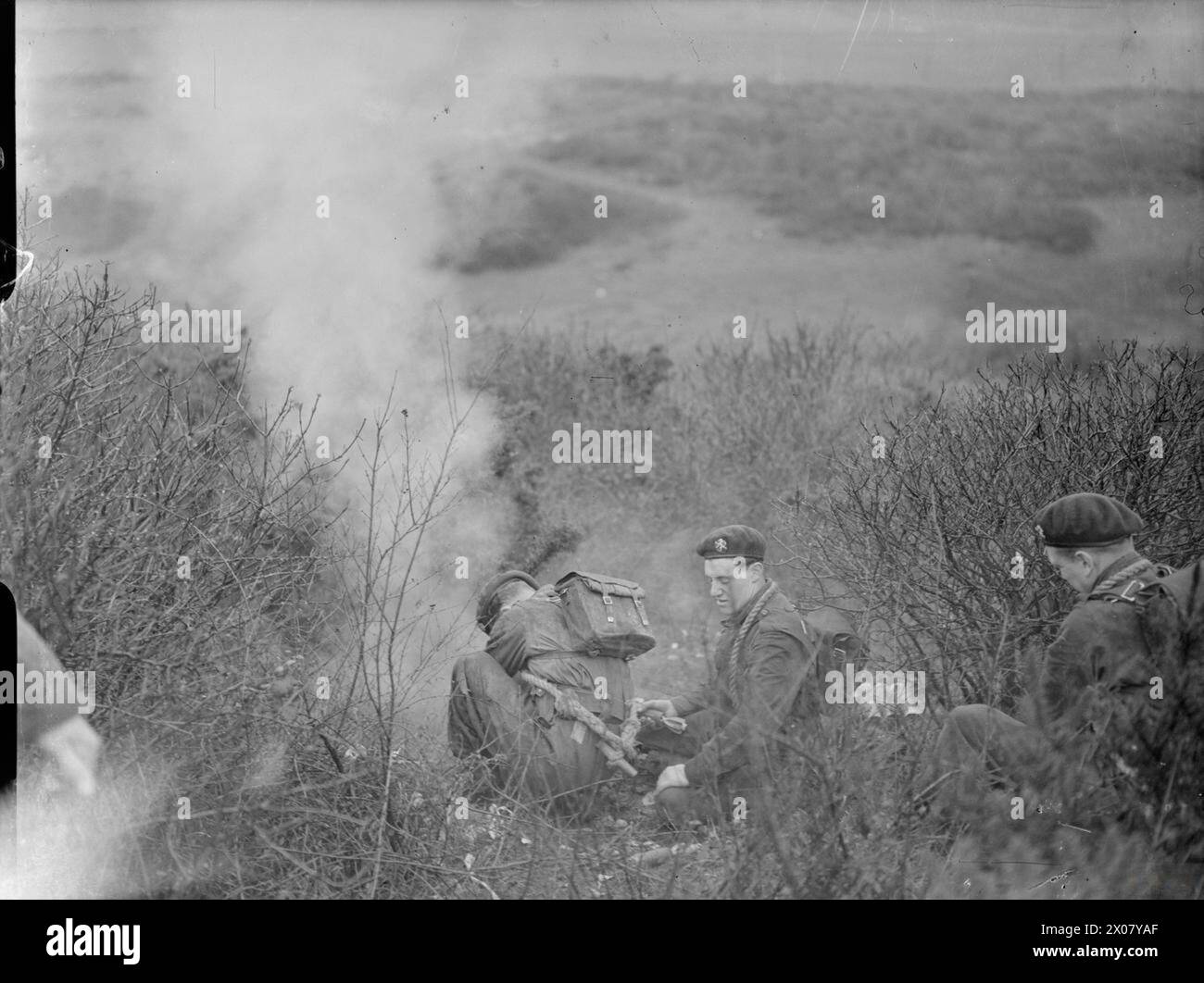 BELGISCHE KOMMANDOS IN AUSBILDUNG IN GROSSBRITANNIEN, 1945 - im Rahmen ihrer Ausbildung in Großbritannien feuern drei belgische Soldaten, die für Mörser verantwortlich sind, vor einem Angriff eine Rauchbombe ab Stockfoto