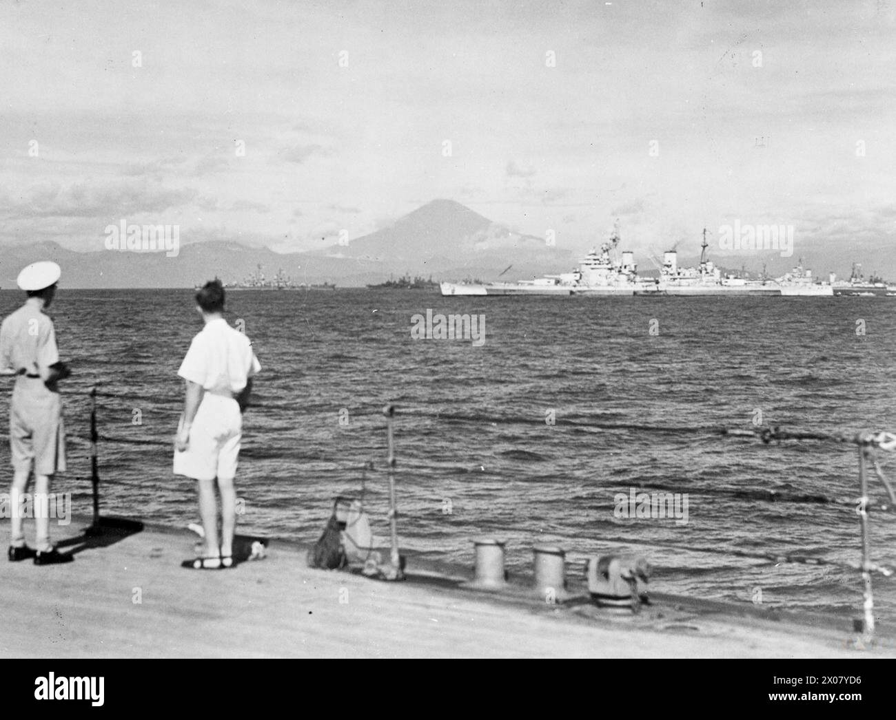 BRITISCHE SCHIFFE IN DER SAGAMI BAY. 31. AUGUST 1945, AN BORD DER HMS DUKE OF YORK, FLAGGSCHIFF DES ADMIRAL SIR BRUCE FRASER, C IN DER BRITISCHEN PAZIFIK-FLOTTE. - Alliierte Schiffe in der Sagami-Bucht, vom Quartierdeck der HMS DUKE OF YORK aus gesehen. Von links nach rechts: HMS GAMBIA, HMS KING GEORGE V (nächstgelegen) und HMS NEUFUNDLAND. Der Fujiyama ist im Hintergrund Stockfoto