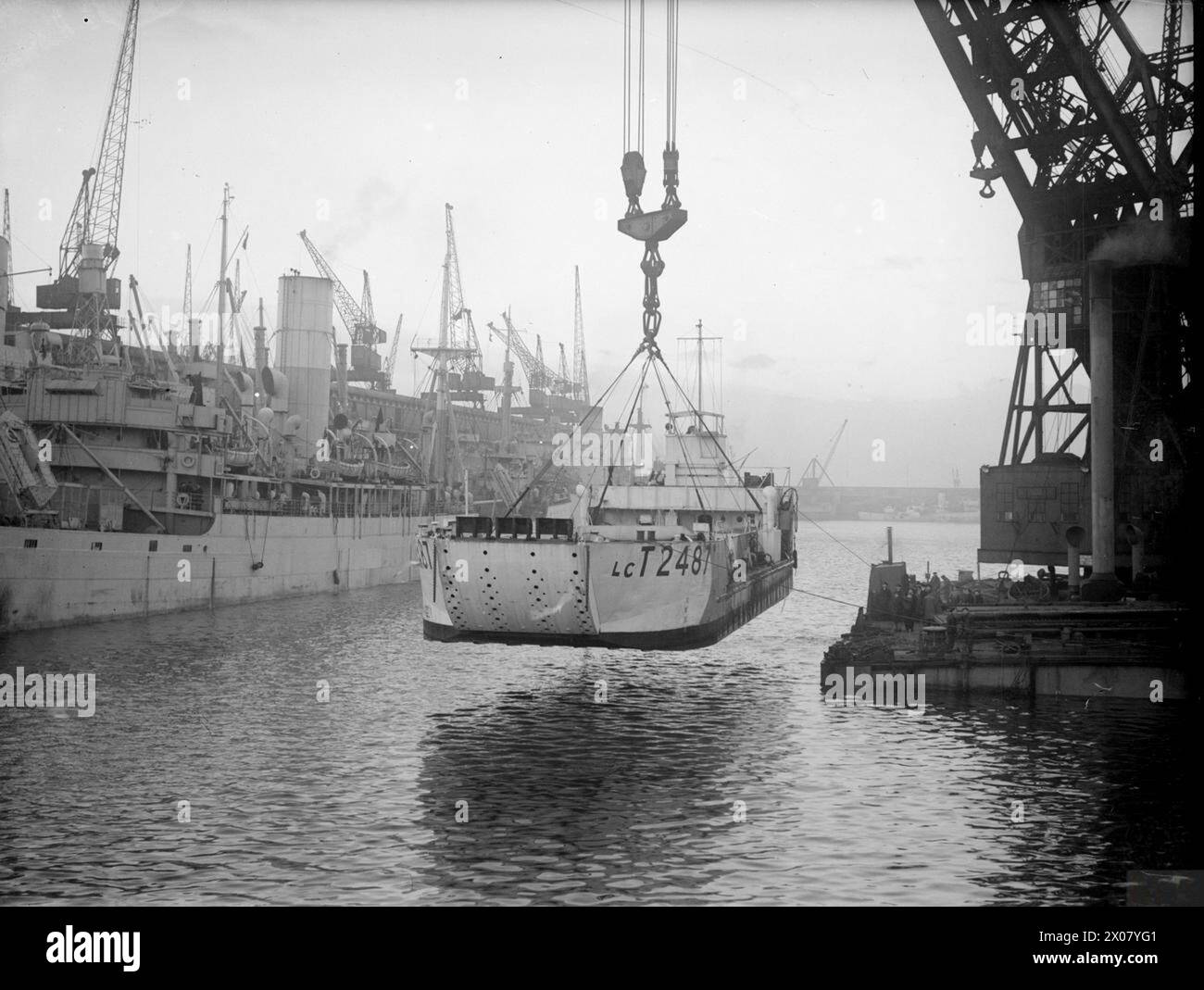 Am 7. Dezember 1944 hob der Riesenkran „Mammoth“ am Gladstone Dock in Liverpool ein 147 Tonnen schweres Tanklandefahrzeug aus dem Wasser auf das Deck eines Tanklandeschiffs. Stockfoto