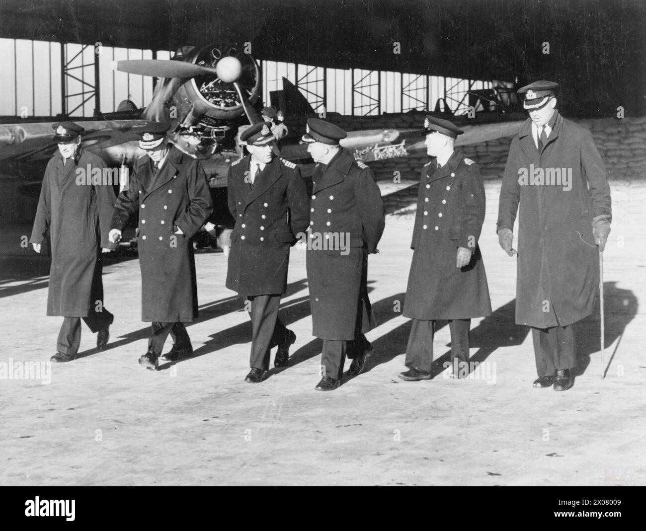 LUFTWAFFENAKTIVITÄTEN DER FLOTTE BEI HMS SPARROWHAWK, ROYAL MARINEFLUGSTATION HATSTON. MÄRZ 1942. - Konteradmiral Naval Air Stationen besuchen die Basis. Von links nach rechts: Lieut Cdr (A) N E Goddard, DSC, RNVR, Pilot der Maschine, die zuerst über Bergen flog, um den BISMARCK zu entdecken, für den er den DSC erhielt; Konteradmiral C Moody, Conteradmiral Naval Air Stations; Captain H L St J Fancourt, RN; Commander H A Traill, OBE, RN; Flag Lieut Cdr Smallwood, RN; und Commander N S Luard, DSC, RN Stockfoto