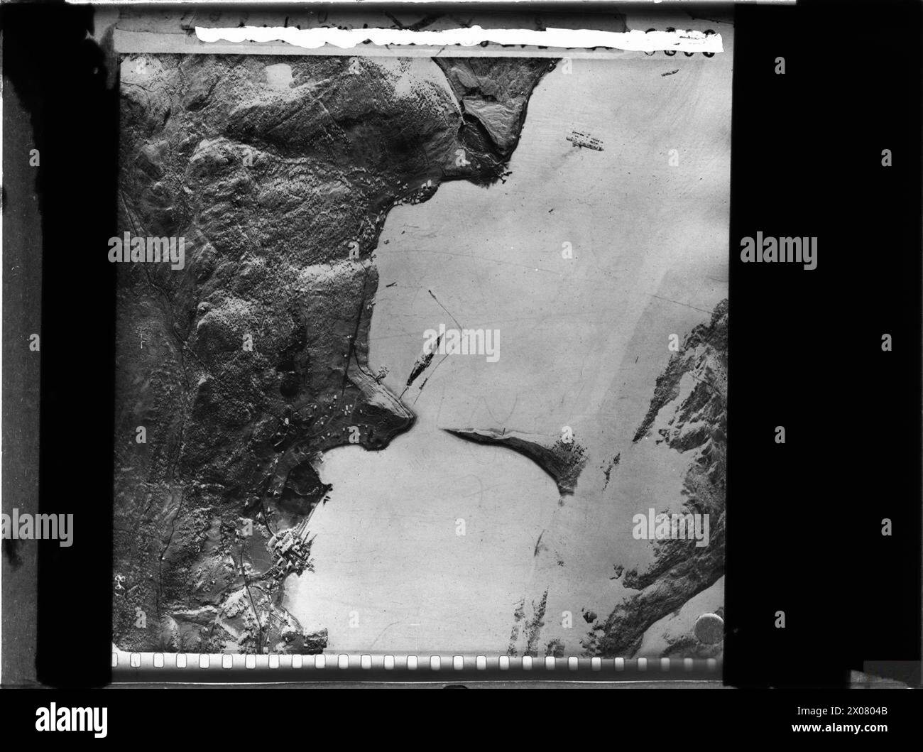 Die Luftaufklärung des Alten Fjords zeigt das deutsche Schlachtschiff Tirpitz vor Anker mit einem L-förmigen Torpedonetz. Das Schiff wurde von britischen Zwerg-U-Booten angegriffen und beschädigt. Stockfoto