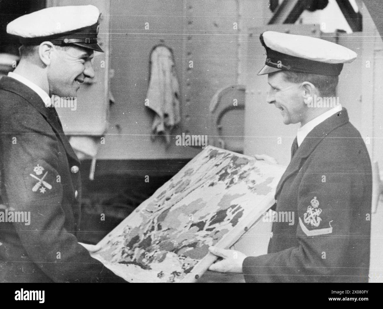 Im Juli 1945 dienten Männer an Bord verschiedener Schiffe im Fernen Osten gegen japanische Truppen. Petty Officer James Mollison von der HMS Swiftsure aus Stevenstown, Ayrshire, zeigte Petty Officer Fryers aus Portsmouth einen Feuerschirm, den er in seiner Freizeit gemacht hatte. Stockfoto