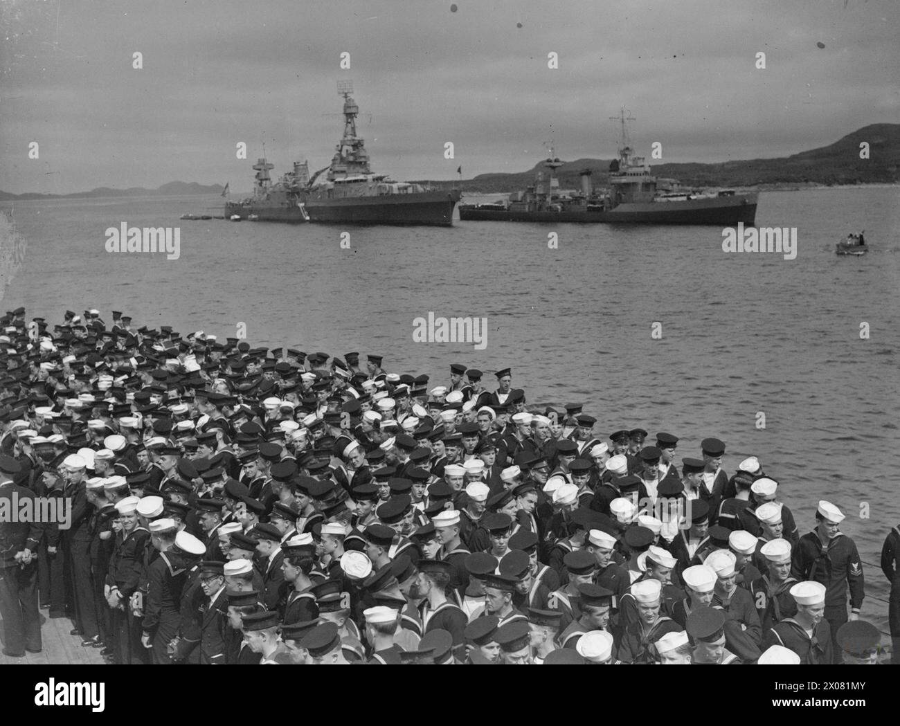 PRÄSIDENT ROOSEVELT TRIFFT PREMIERMINISTER CHURCHILL. 10. AUGUST 1941 AN BORD DER HMS PRINCE OF WALES IM NORDATLANTIK VOR NEUFUNDLAND. DIE TREFFEN FANDEN AN BORD DES SCHLACHTSCHIFFS HMS PRINCE OF WALES UND DES AMERIKANISCHEN KREUZERS USS AUGUSTA STATT, DIE TREFFEN BEGANNEN AM 9. AUGUST 1941. - Britische und amerikanische Seeleute an Bord der HMS PRINCE OF WALES beim Divine Service. Im Hintergrund sind die USS AUGUSTA und der Zerstörer USS MCDOUGAL (rechts) United States Navy, AUGUSTA (USS), schwerer Kreuzer (1930), United States Navy, USS MCDOUGAL, Zerstörer (1936) Stockfoto