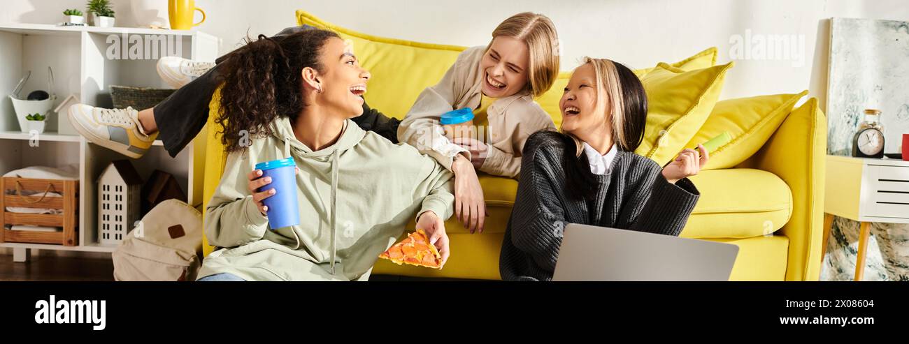 Eine vielfältige Gruppe von Mädchen im Teenageralter, verschiedenen Rassen, sitzen zusammen auf einer hellgelben Couch, lächeln und plaudern, um die Schönheit von Friendshi zu zeigen Stockfoto