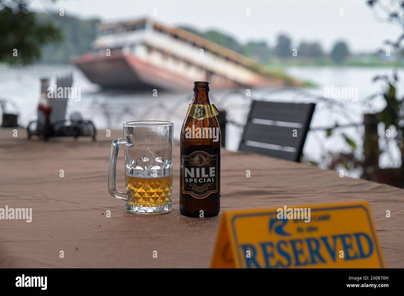 SÜDSUDAN, Hauptstadt Juba, Weißer Nil Fluss, versunkenes Flussschiffswrack, Blick vom Apex Restaurant, ugandian Nil Beer / SÜDSUDAN, Hauptstadt Juba, gesunkenes Flußschiff am Weißen Nil Fluß, Blick vom Apex Restaurant mit Nile Bier Stockfoto