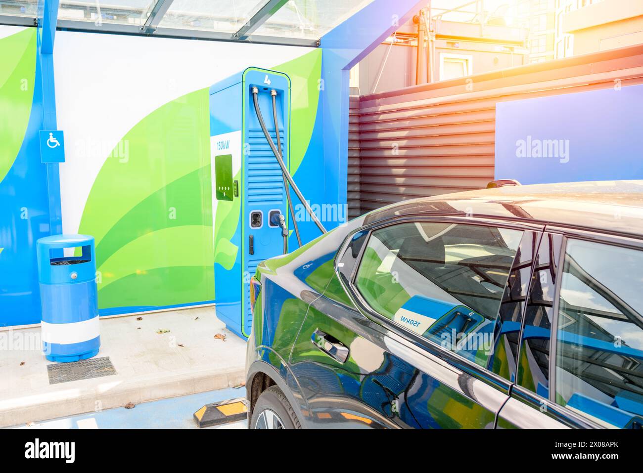 Elektroauto an einer Ladestation an einem sonnigen Sommertag. Umweltfreundliches Konzept für alternative Energien. Stockfoto