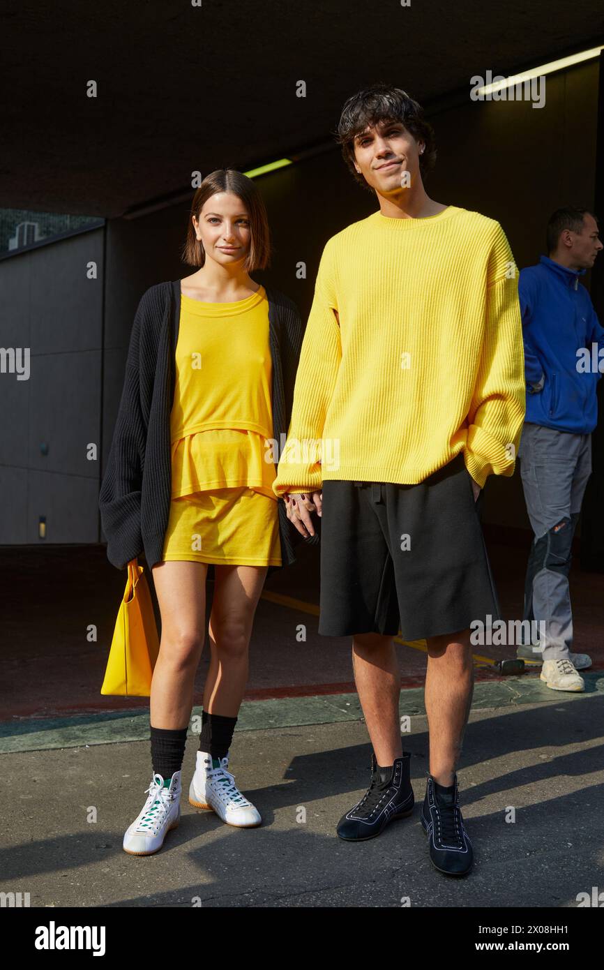MAILAND, ITALIEN - 21. FEBRUAR 2024: Frau und Mann mit gelbem Hemd vor der Modeschau Onitsuka Tiger, Mailand Fashion Week Street Style Stockfoto