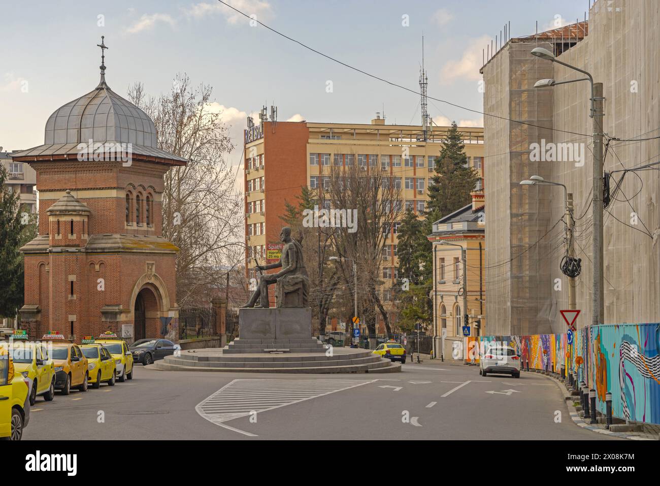 Craiova, Rumänien - 16. März 2024: Eingangsturm mit dem Bogentor und Denkmal für Carol I Statue Historisches Wahrzeichen am Frühlingstag des Kreisverkehrs. Stockfoto