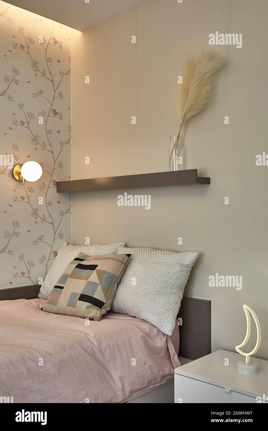 Gemütliches Schlafzimmer mit pastellfarbener Bettwäsche und dekorativer Wand Stockfoto