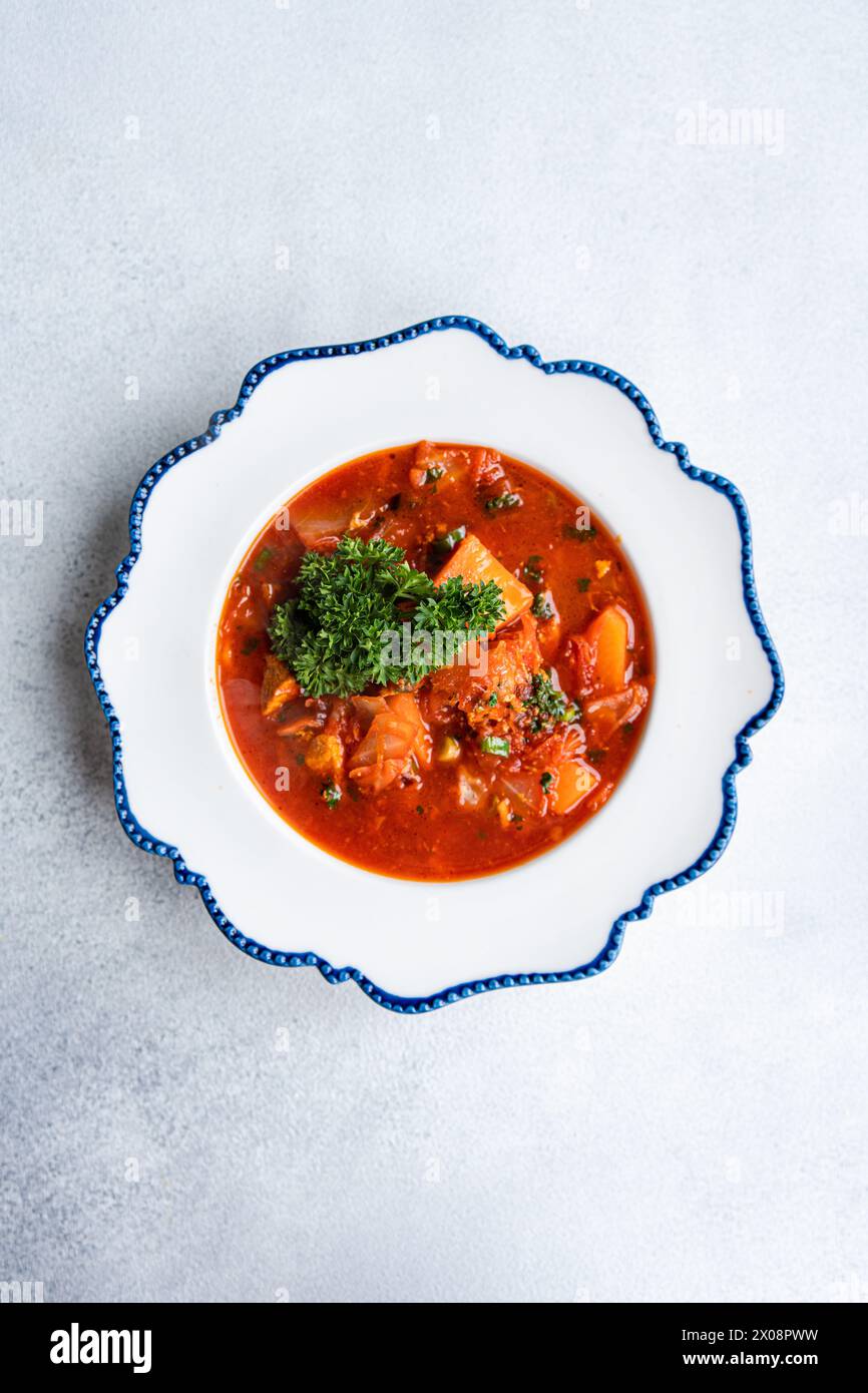 Dieses Bild zeigt eine herzhafte Portion traditioneller ukrainischer Borschtsch, eine Rote-Bete-Suppe mit Fleischstücken und einem Klecks Sauerrahm, garniert mit Stockfoto