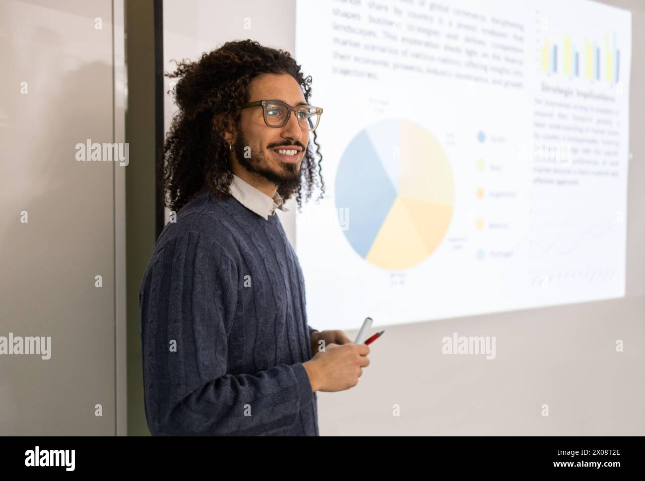 Ein selbstbewusster Mann mit Afro-strukturiertem Haar hält eine Präsentation und blickt von der Kamera weg. Stockfoto