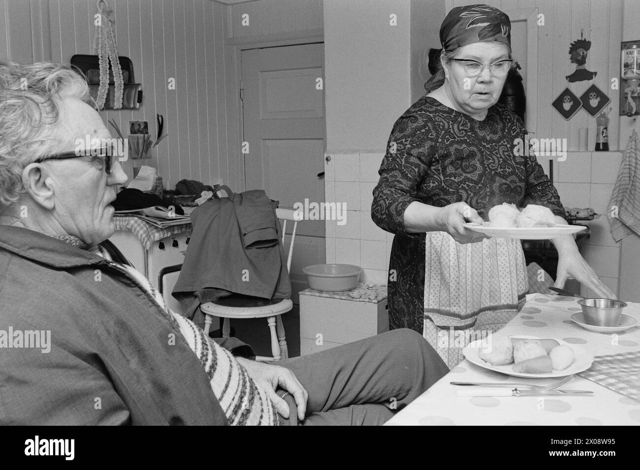 Aktuell 16 - 6 - 1973: Hundert Häuser und ein Mann als vor 20 Jahren war Bjørnsund eine lebendige Gemeinde. Heute ist nur noch eine Person in diesem Fischerdorf übrig. Jetzt wird Bjørnstad ein Touristenziel. Die Leute sind begierig, hier draußen in dieser Einsamkeit ein Haus zu kaufen. Borghild Gornitchin ist mit Bjørnsund verbunden. Sie kehrt jedes Jahr zurück, lange vor den Zugvögeln. Für den Einsiedler Rolf Thoresen wird das Leben viel heller, wenn Borghild nach Hause kommt, nachdem er den Winter mit einer Tochter in Østfold verbracht hat. Oft bleibt sie mit einem guten Abendessen auf, wie hier. - Wenn Stockfoto