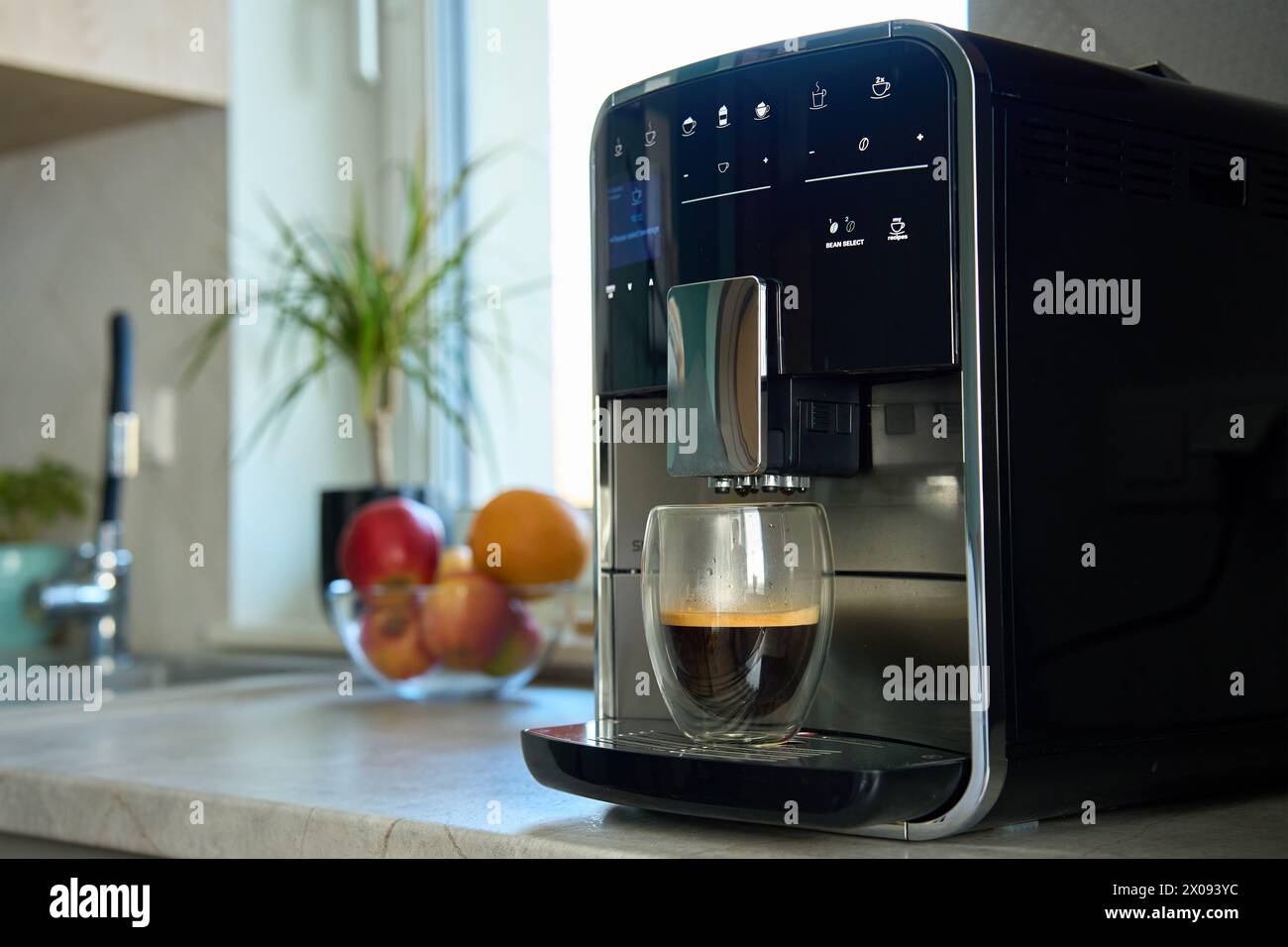 Frischer Espresso am Morgen. Kaffeemaschine in der Küche, Nahaufnahme. Moderne Kaffeemaschine mit frisch gebrühtem Kaffee in Glasbecher. Küchengeräte Stockfoto