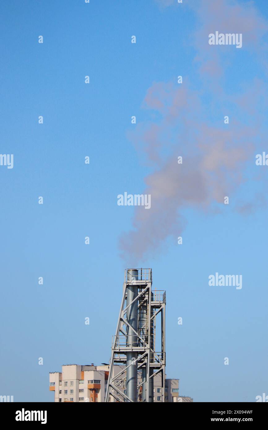 Eine Metallpfeife und Rauch, der aus der Stadt kommt. Stockfoto