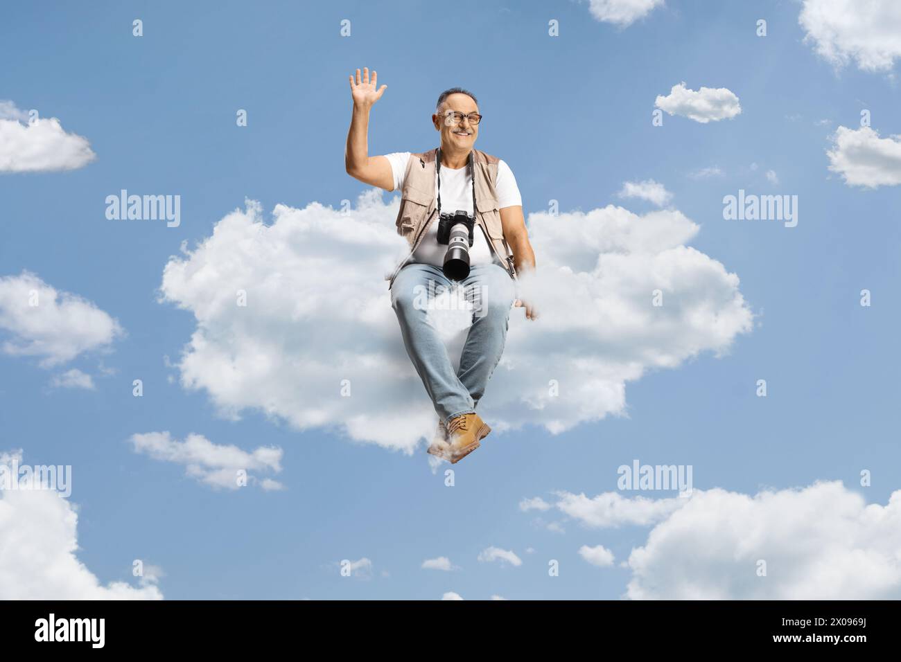 Fotograf mit einer Kamera, die auf einer Wolke sitzt und winkt Stockfoto