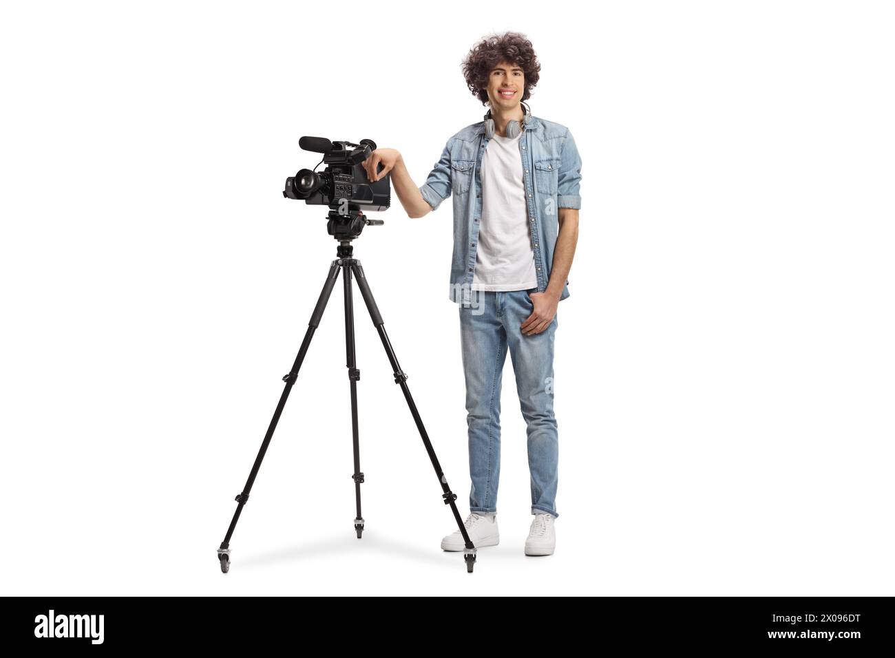 Porträt eines Kamerabedieners in voller Länge mit einer Kamera auf einem Stativstativ, isoliert auf weißem Hintergrund Stockfoto