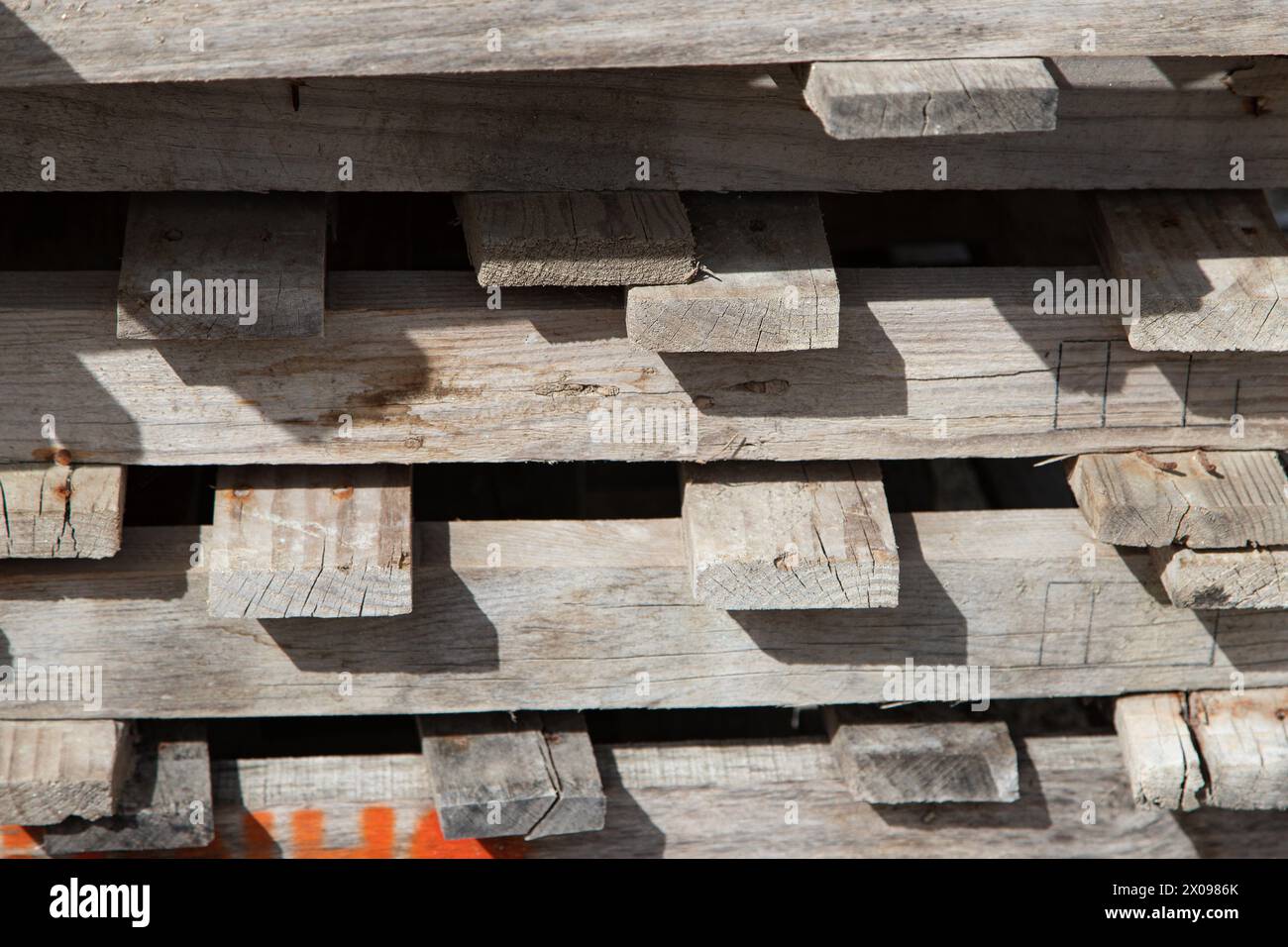 Hintergrund alter Holzpaletten, die im Außenbereich übereinander gestapelt sind. Holzdielen nah, Textur Stockfoto