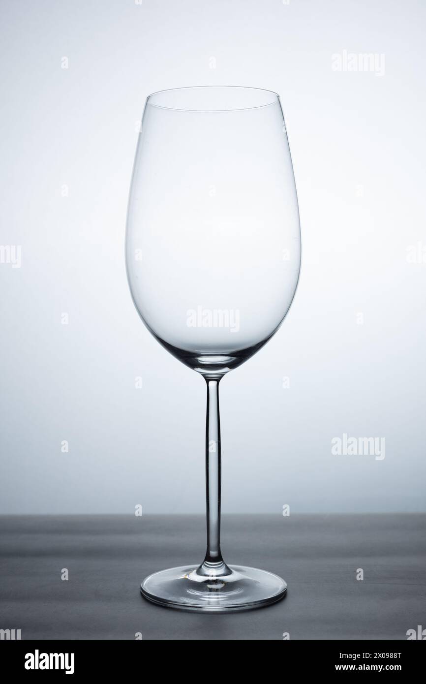 Klares Kristallweinglas mit elegantem Standfuß aus leerem Glas ohne Flüssigkeit auf einem Tisch Stockfoto