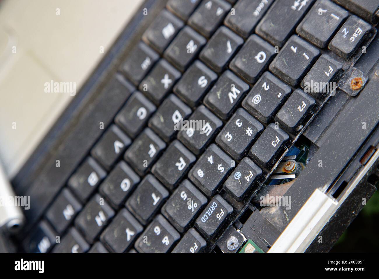 Detail der nicht verwendeten, beschädigten Laptop-Tastatur. Veraltete technologische Produkte. Stockfoto