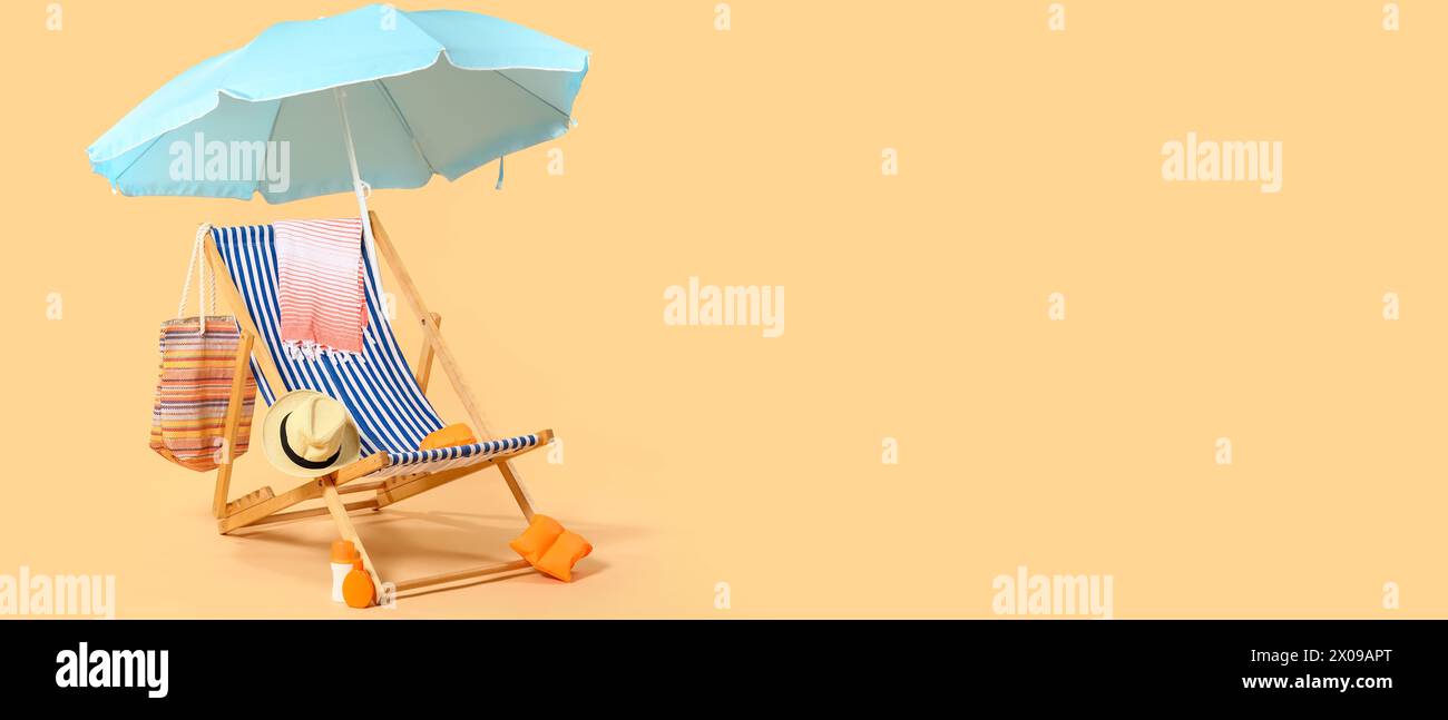Liegestuhl, Sonnenschirm und Strandaccessoires auf beigefarbenem Hintergrund mit Platz für Text Stockfoto