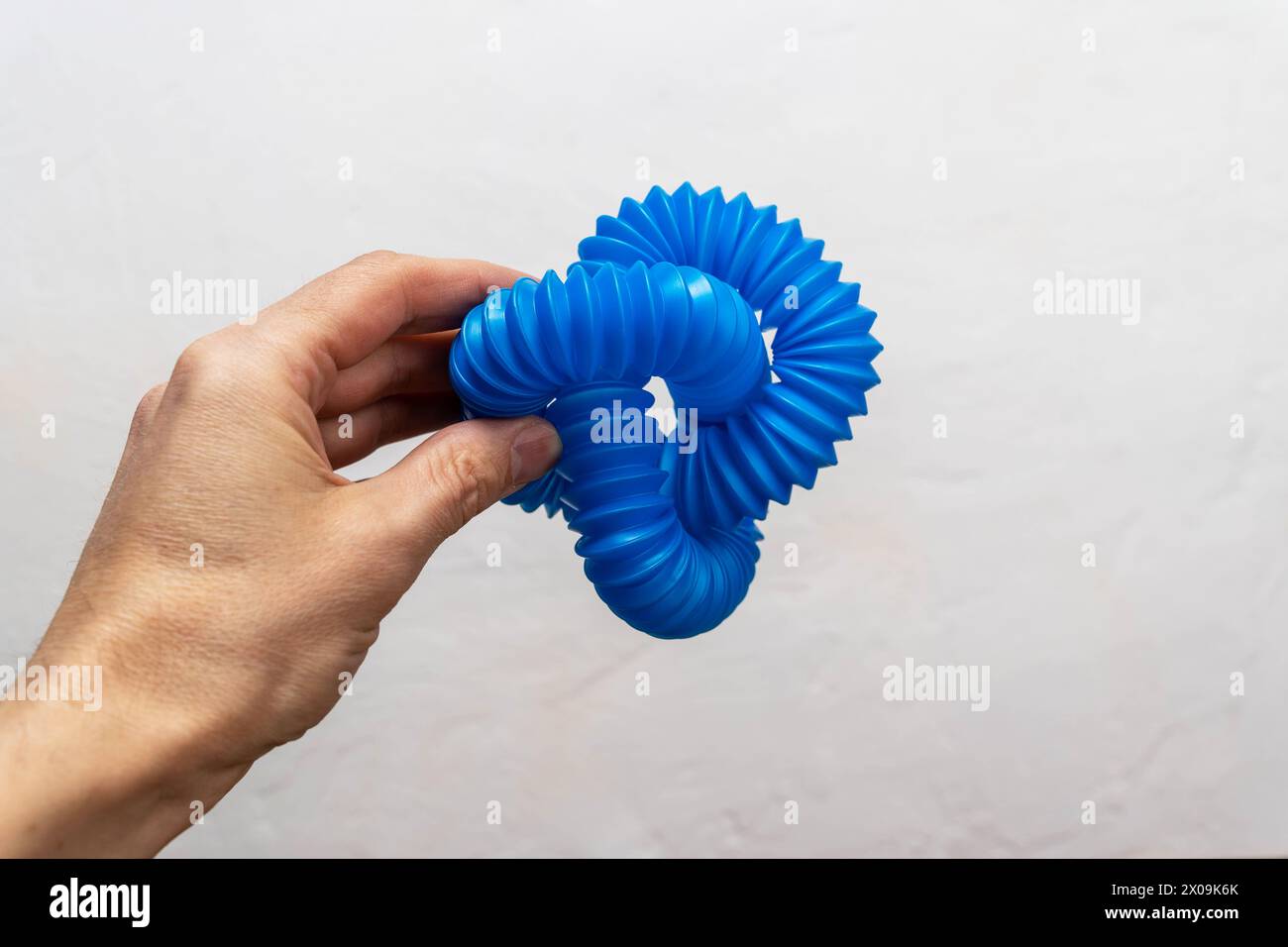 Blaues Spielzeug für Kinder mit Wellpappe. Pop Tubes, Pfeifenakkordeon, Antistress. Stockfoto